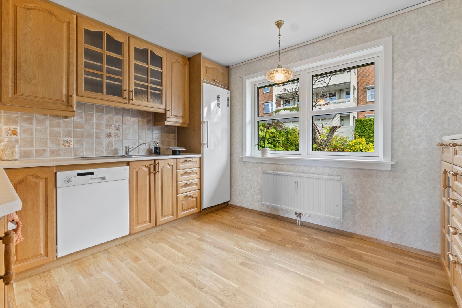 Kjøkkenfronter i eiketreutførelse. Benkeplater i laminat med innfelt vask og platetopp. Galleribilde