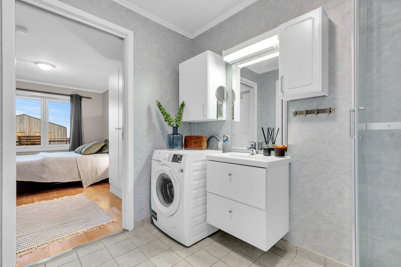 Badet er utstyrt med dusjkabinett, gulvmontert wc og opplegg for vaskemaskin. Galleribilde