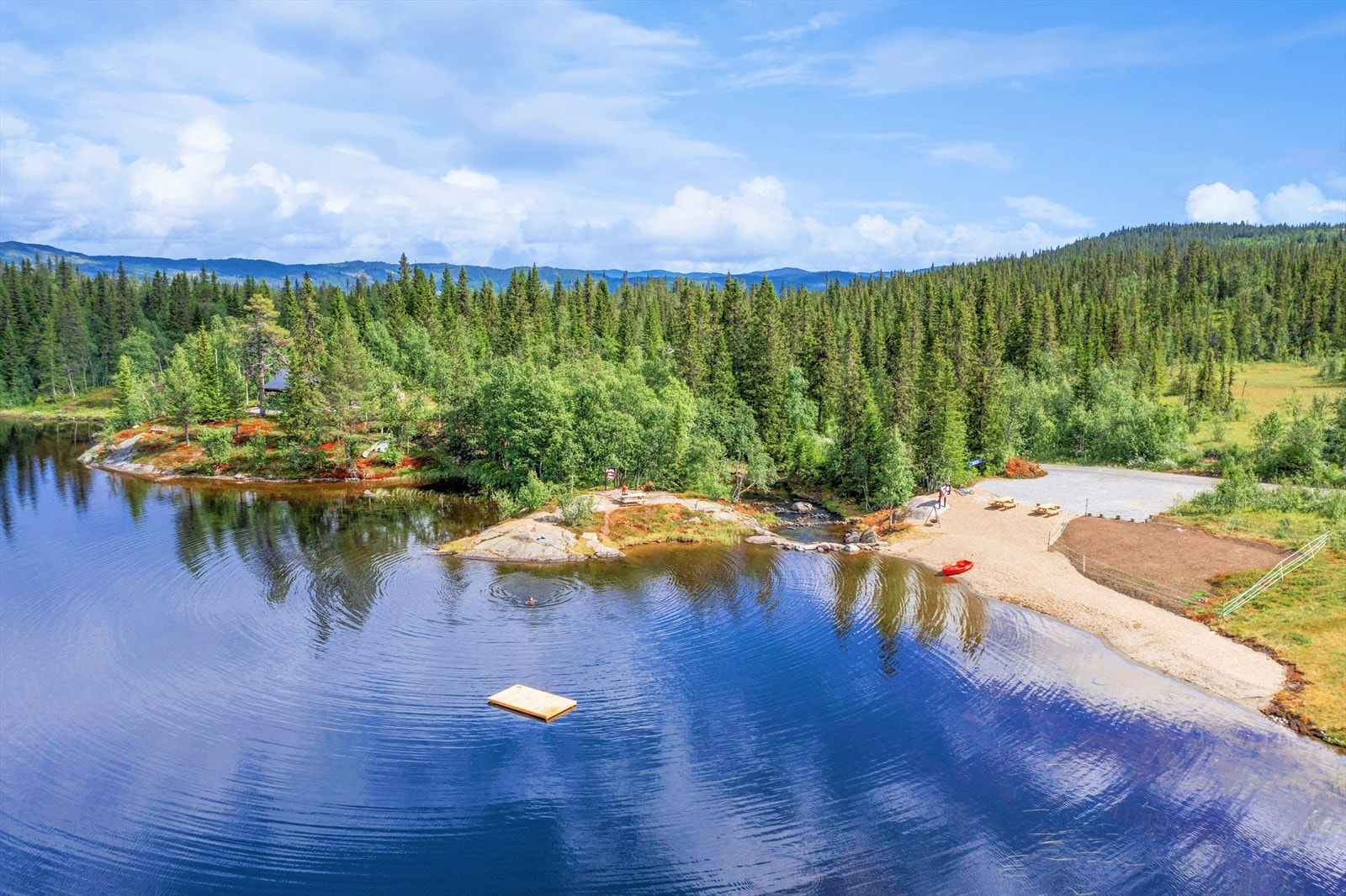 Badeplassen i Damtjern er like nedenfor hytten med badeflåte, benker og bålpanne. Galleribilde