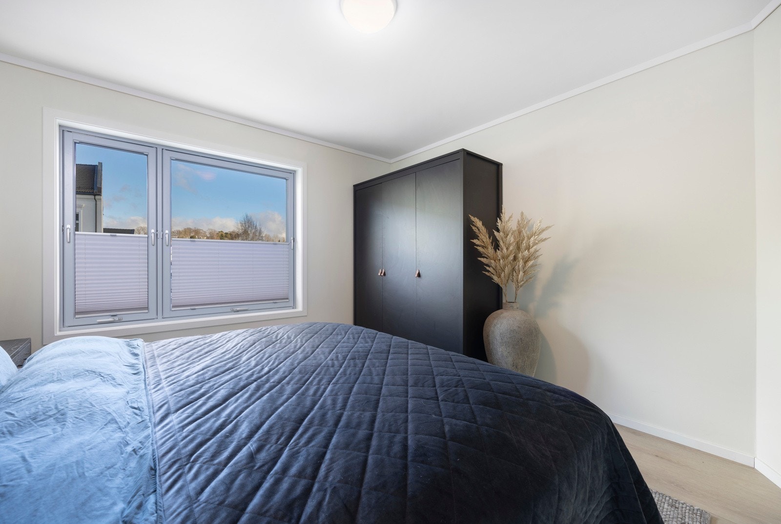 Stort vindu med plissegardiner som slipper inn rikelig med naturlig lys Galleribilde