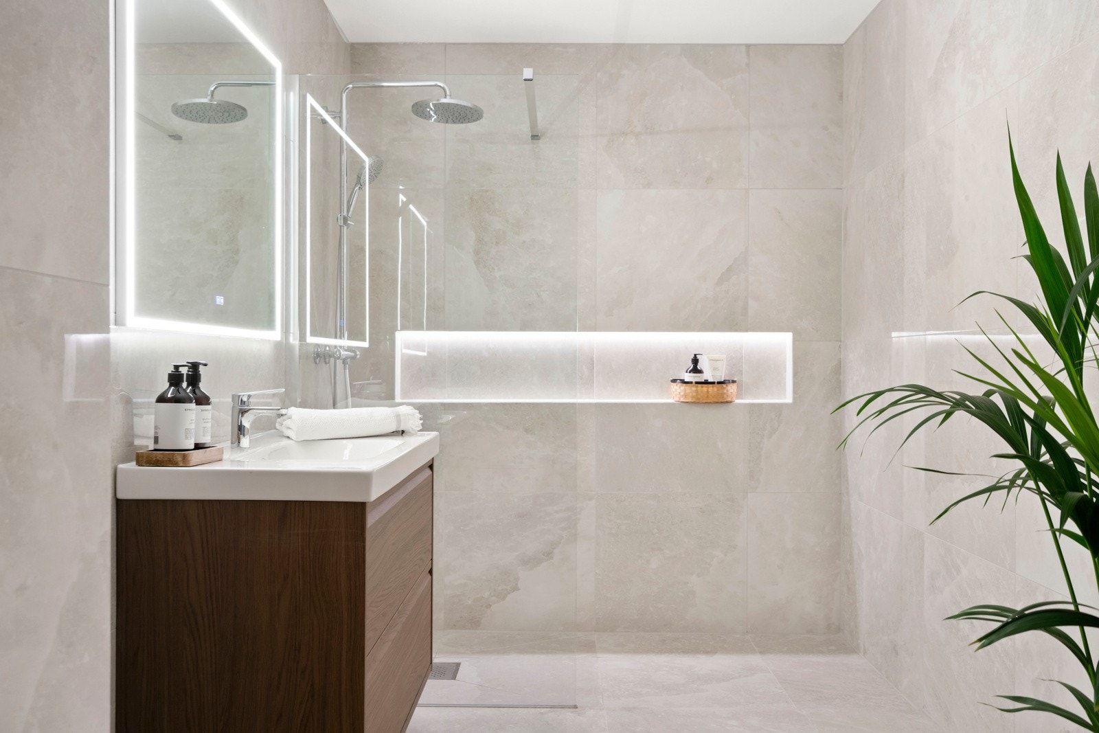 Baderommet byr på servant servantskap med glatte, folierte fronter og heldekkende servant, samt speil med integrert belysning på vegg over servant. Galleribilde