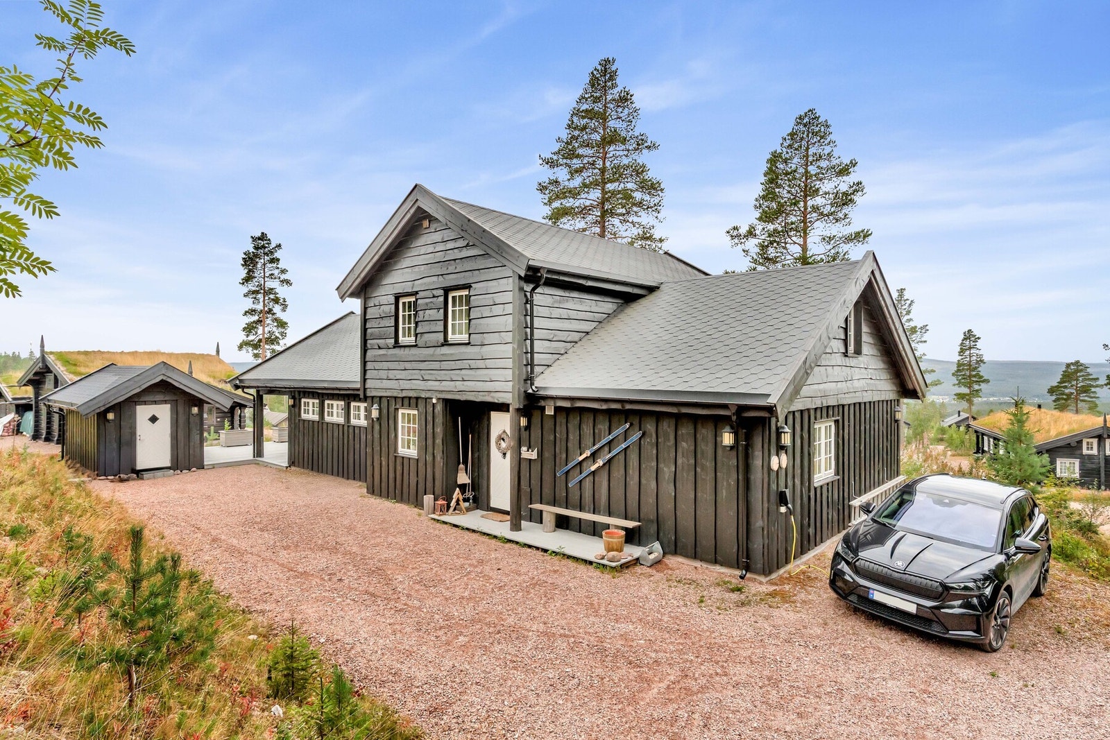 Det er en gruslagt innkjørsel med flere parkeringsplasser og el-billader som gjør det enkelt for både gjester og familien å komme og gå. Galleribilde