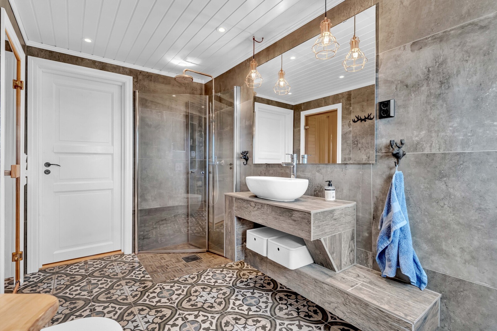 Badet har forøvrig vegghengt servantinnredning, speil med overlys, dusjhjørne med hånddusj og regndusj og vegghengt toalett. Galleribilde