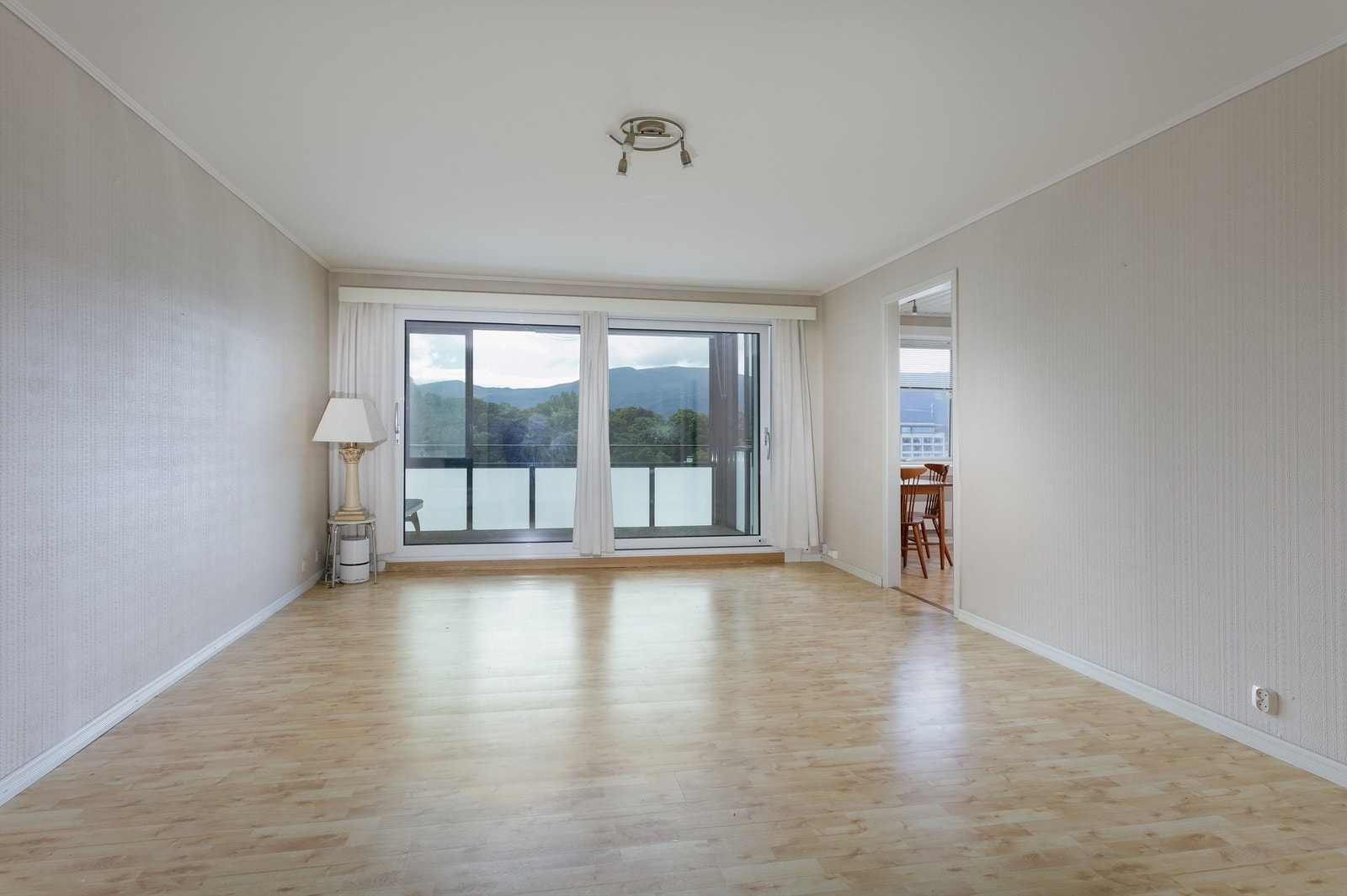 Stue med lyse overflater og utgang til innglasset balkong Galleribilde