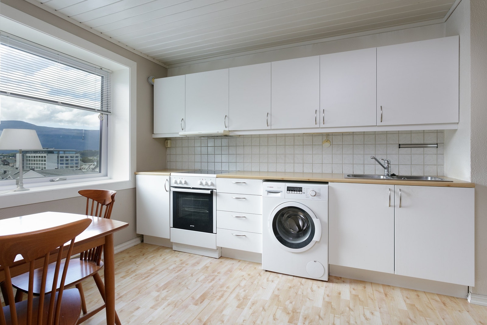 Kjøkkeninnredning med glatte fronter. God plass til spisebord på kjøkkenet Galleribilde