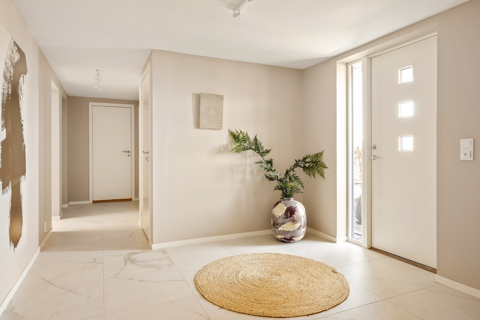 Stor og innbydende gang/hall som setter standarden for resten av boligen. Legg merke til de eksklusive storformalflisene på gulvet. Galleribilde