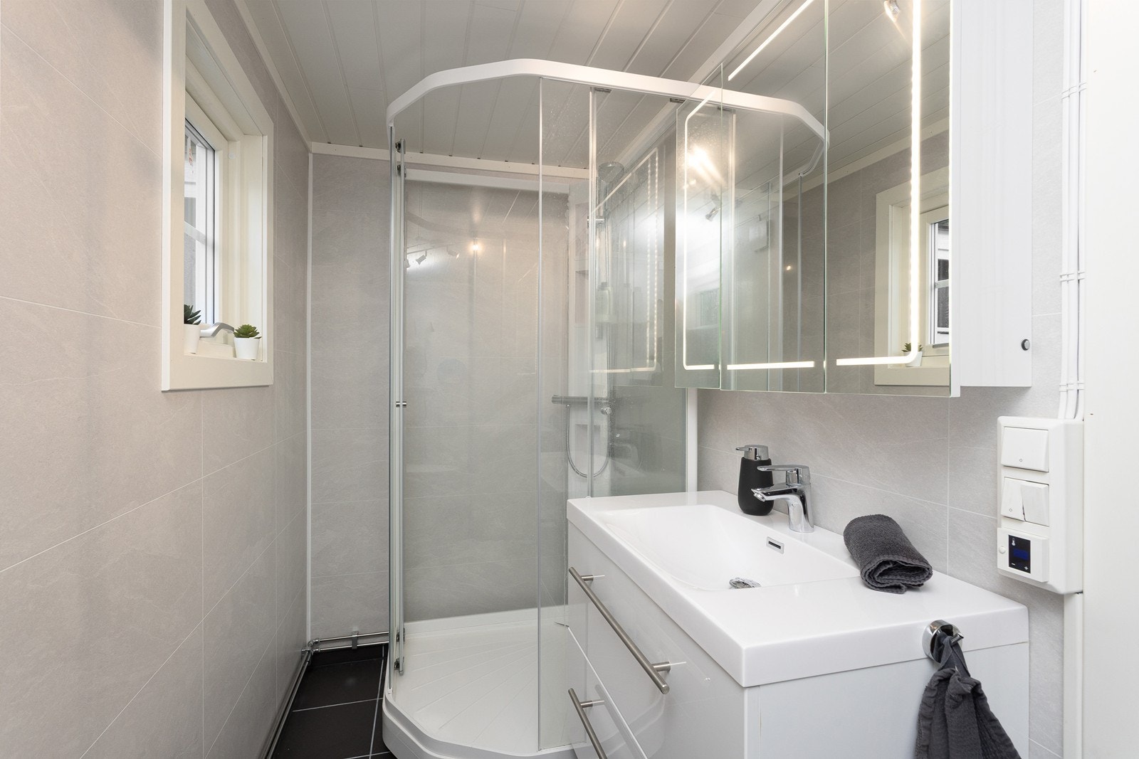 Delikat og moderne baderom fra 2020. Veggene har baderomsplater. Taket har smartpanel. Gulvet er flislagt. Rommet har elektriske varmekabler. Galleribilde