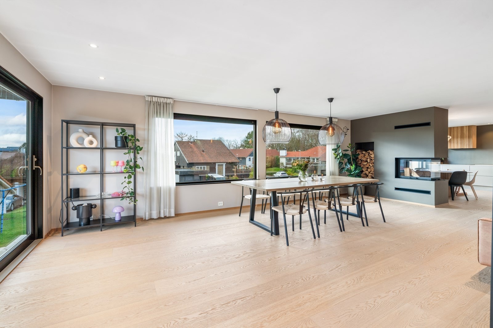 Lys og romslig spisestue med store vinduer og moderne design. Perfekt for sosiale sammenkomster. Galleribilde