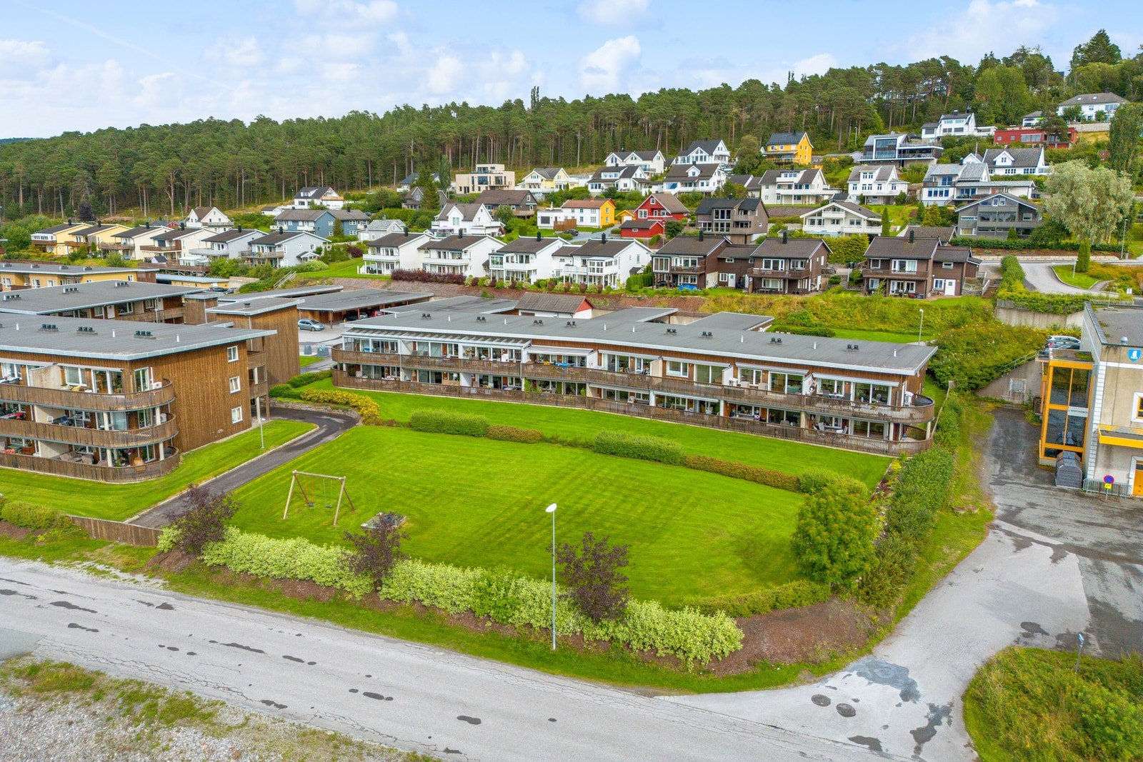Fellesarealet er pent opparbeidet med busker og plen. Godt med boltreplass, samt huskestativ og sandkasse. Galleribilde