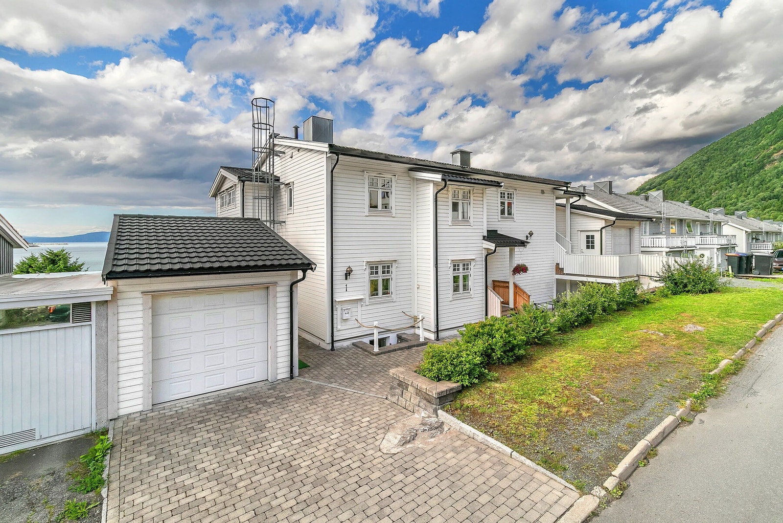 Brosteinsbelagt foran garasje og inngangsparti. Eiendommen har 2 garasjer, der den ene er isolert. Galleribilde