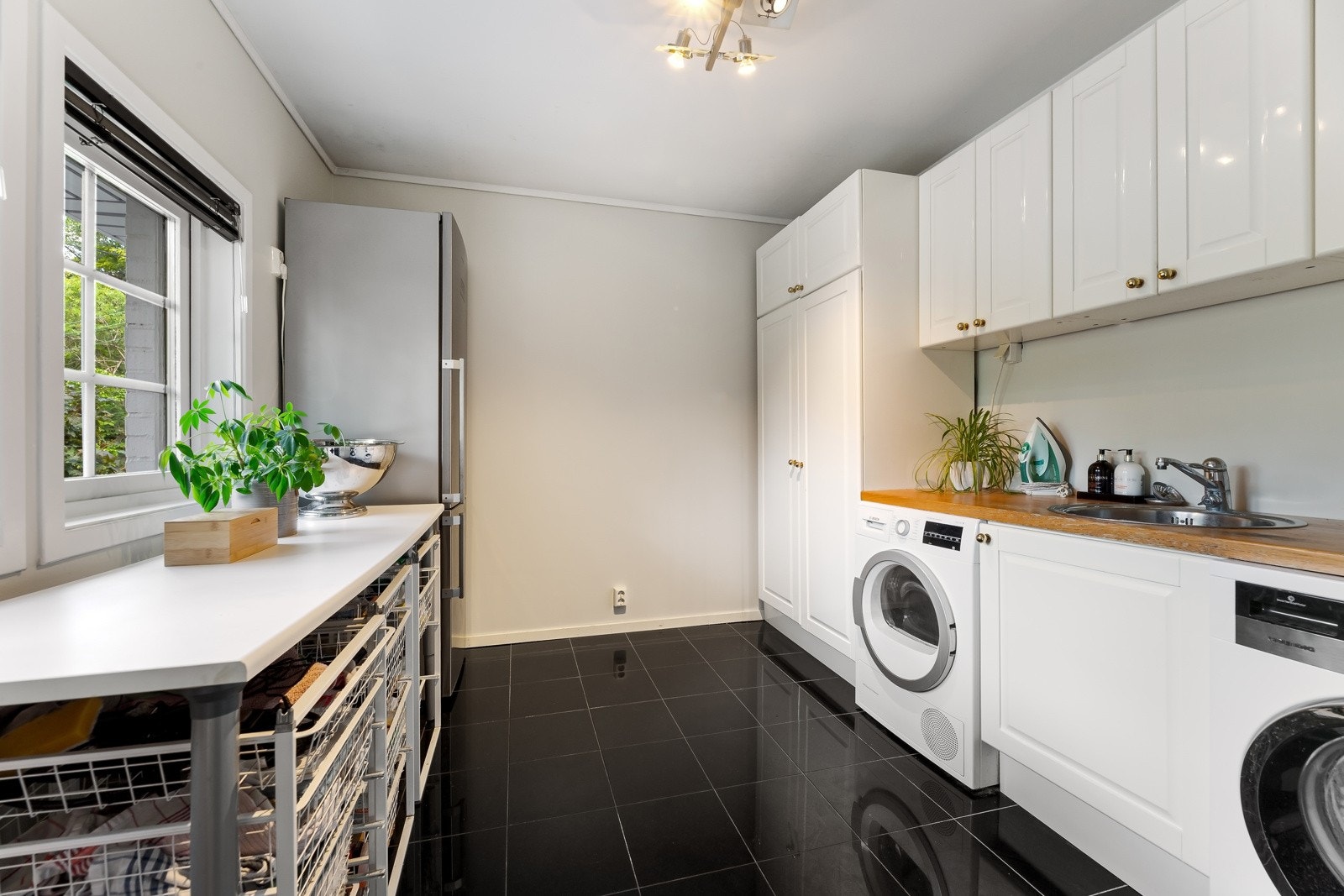 Vaskerommet ligger med adkomst fra kjøkkenet og har nisje til både vaskemaskin og tørketrommel. Det er godt med lagringsplass i innredningen. Galleribilde