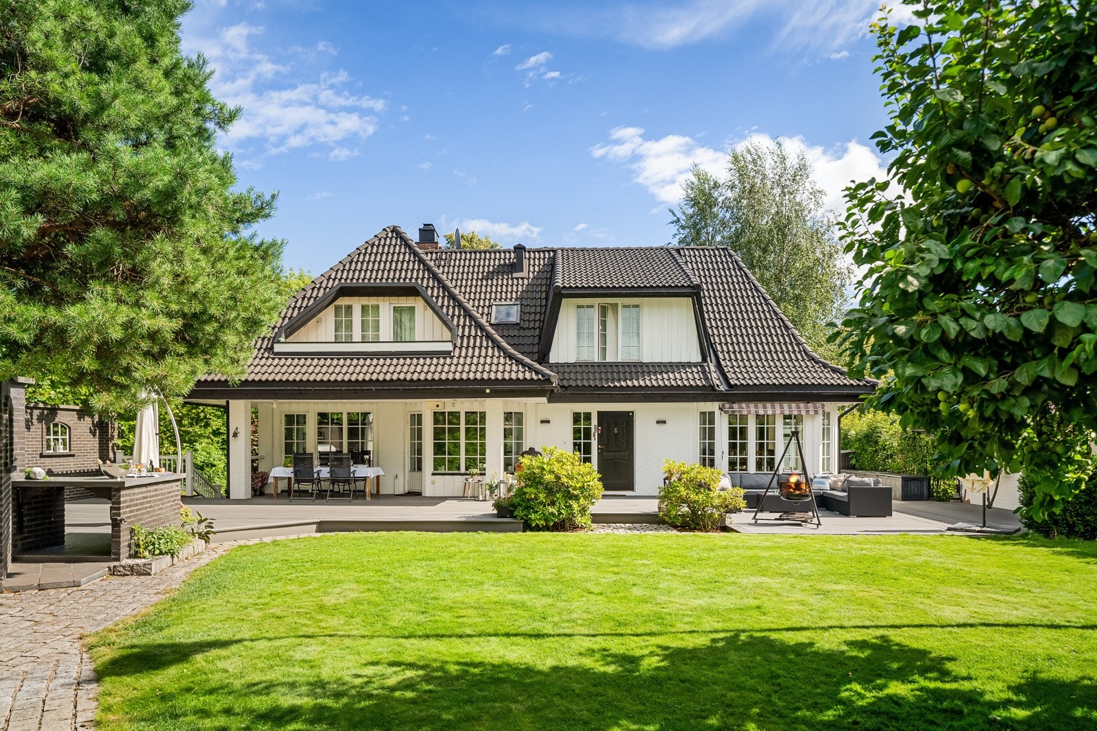 Hagen er en usjenert oase med sol fra morgen til kveld, 180 kvm vedlikeholdsfri terrasse, påkostet utekjøkken og utedusj. Galleribilde