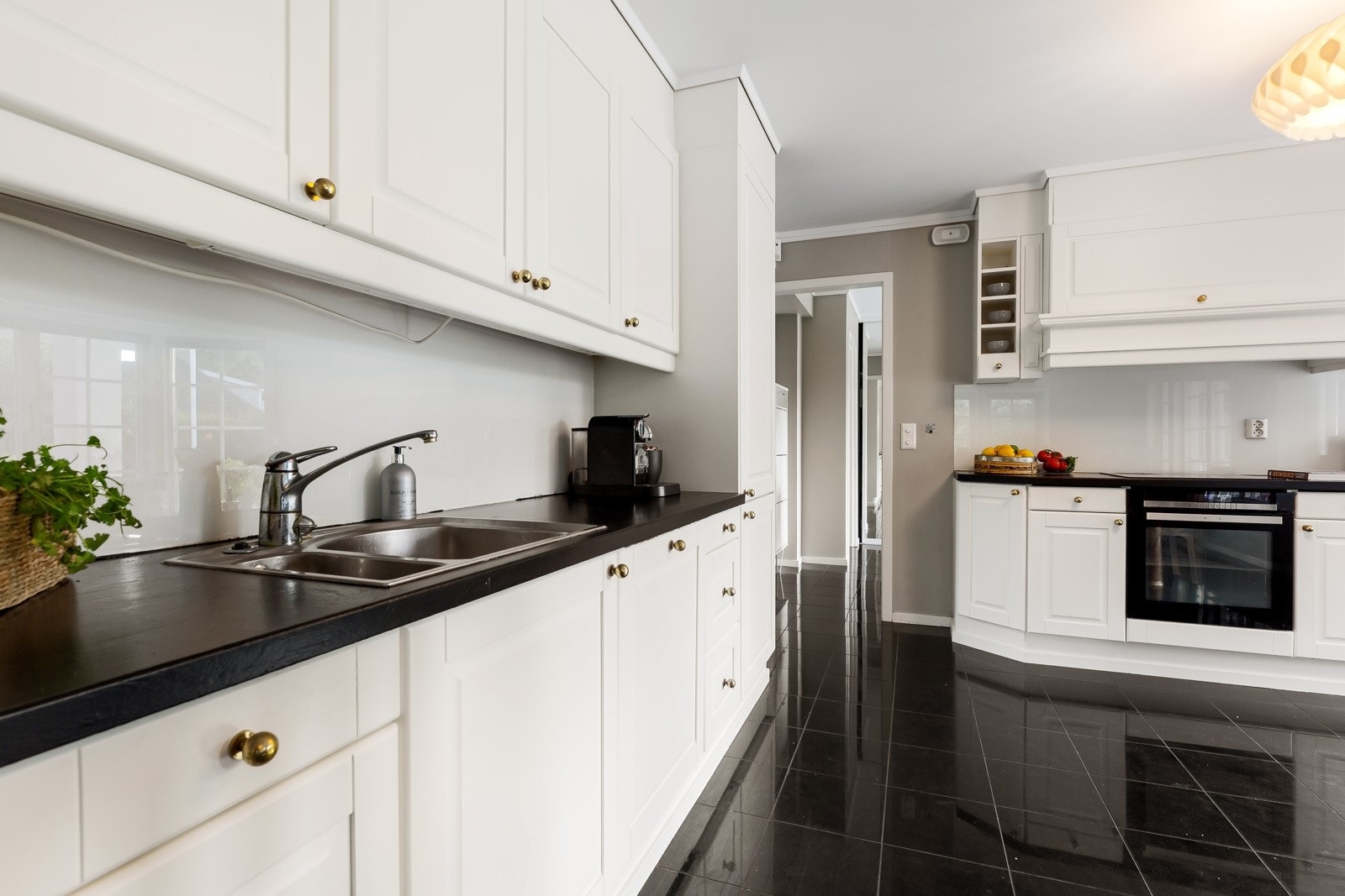 Kjøkkeninnredningen er takoppforet, plassert langs to sider og holdt i en klassisk stil som står seg. Galleribilde