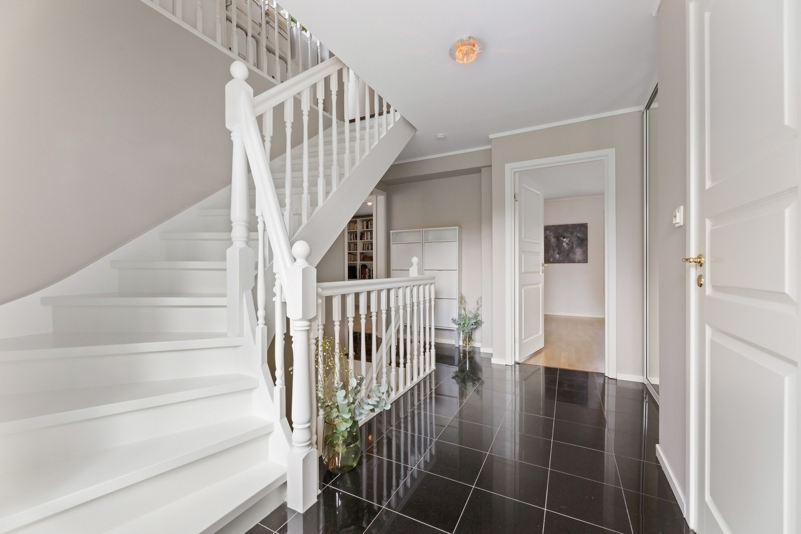 En stor skyvedørsgarderobe med speilfronter er bygd inn i den ene veggen, og langs endeveggen er det montert skoskap. Galleribilde