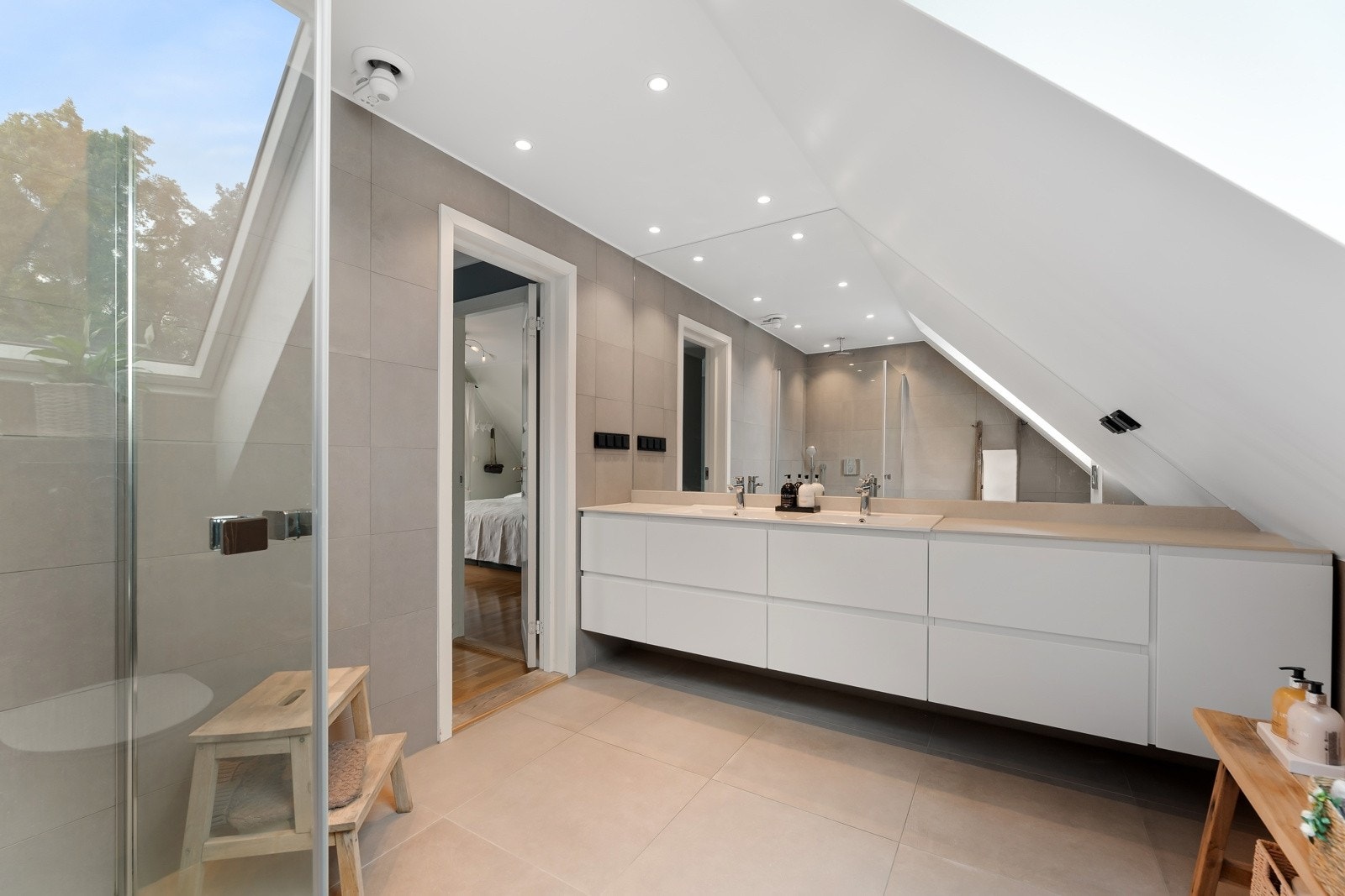 Bad fra 2021 i andre etasje. Badet er romslig og familievennlig innredet med en bred, hvit servantbenk, utstyrt med dobbelservant, flere skuffer og god benkeplass. Galleribilde