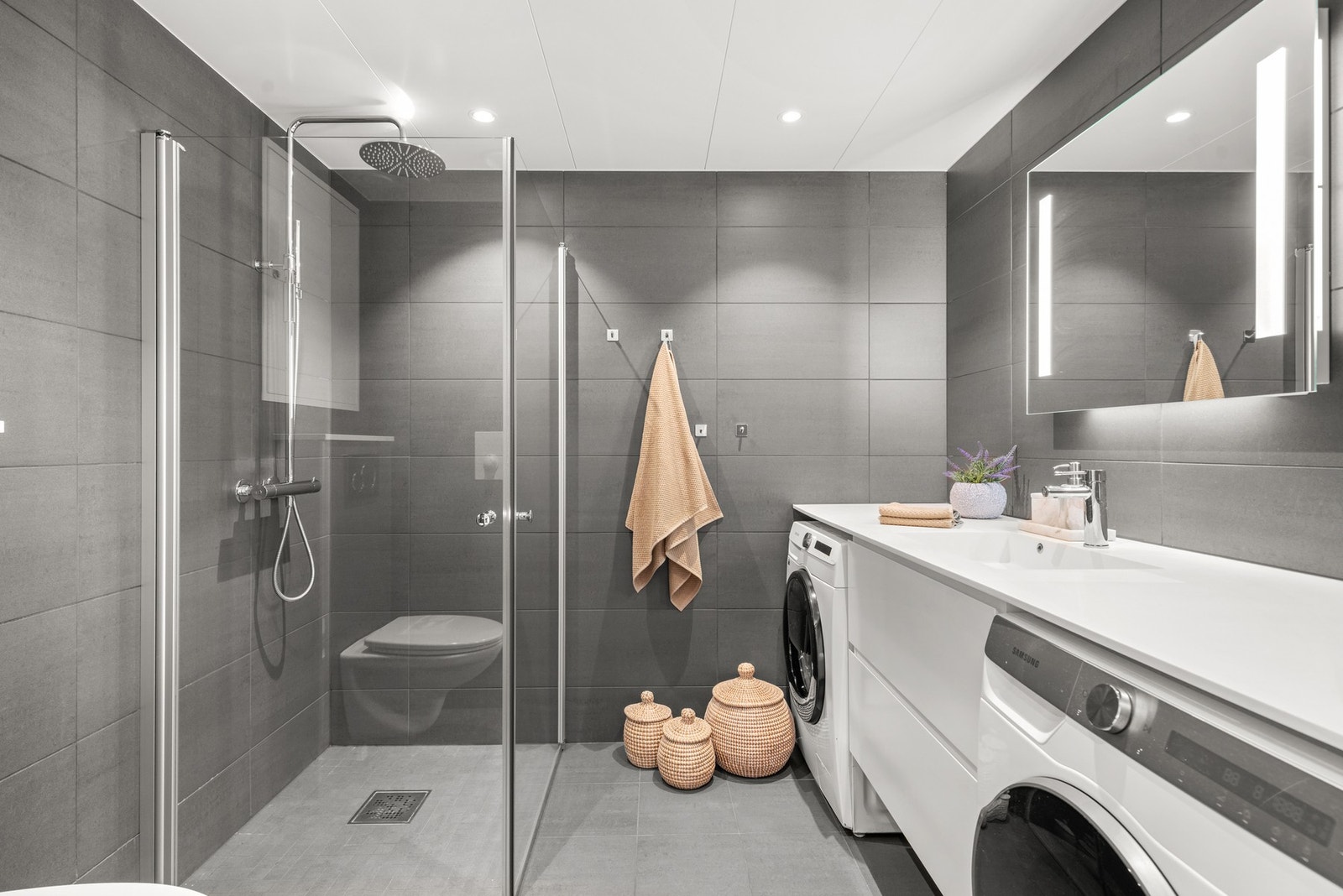 Strøkent og delikat bad med lang, helstøpt servantplate. Luftig og fint bad med dusjvegger som kan slås inn for å gi yttereligere plass. Galleribilde