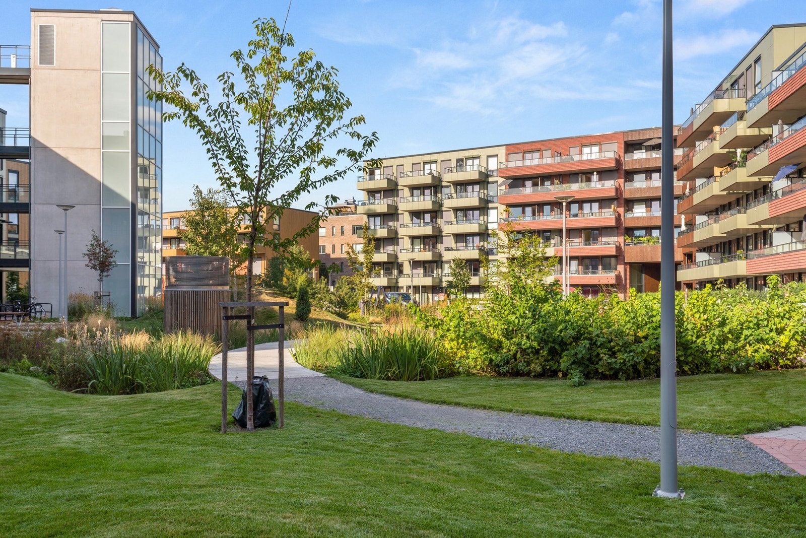 Gårdsrommet er nydelig opparbeidet med bærbusker, sittgrupper, lekeplass og plener. Galleribilde