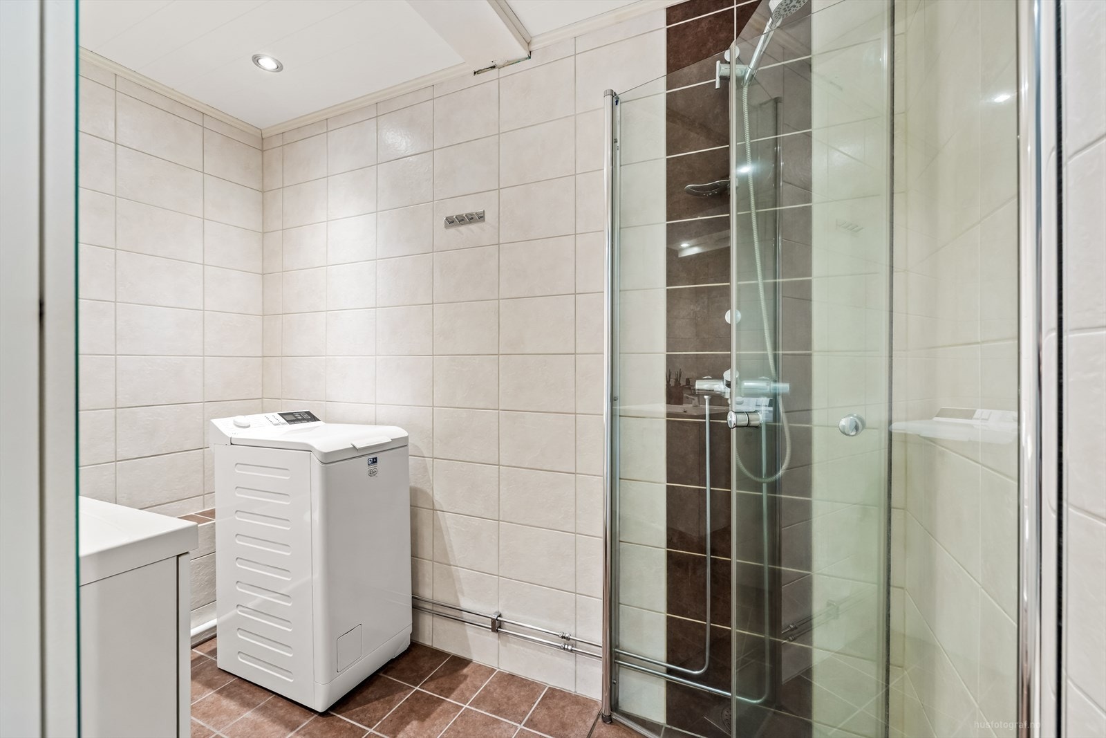 Rommet har innredning med nedfelt, servant, toalett, dusjvegger/hjørne og opplegg for vaskemaskin Galleribilde