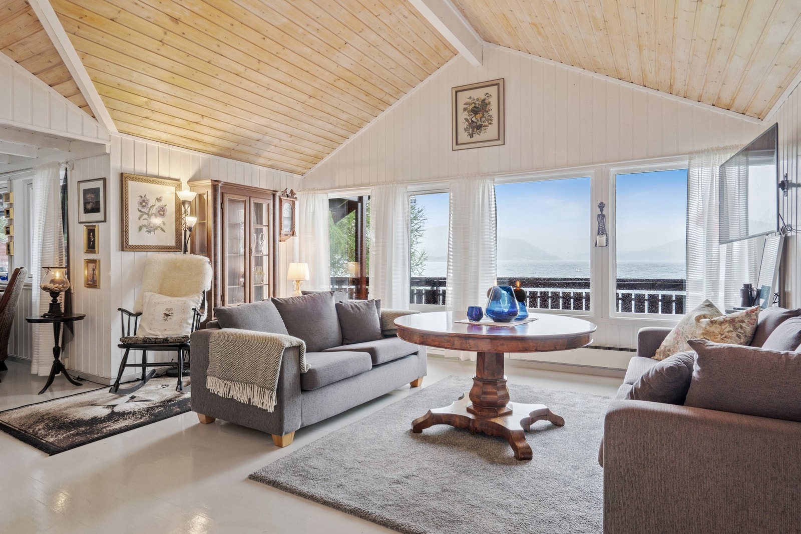 Lys stue med store vindusflater som gir mye naturlig lys. Galleribilde