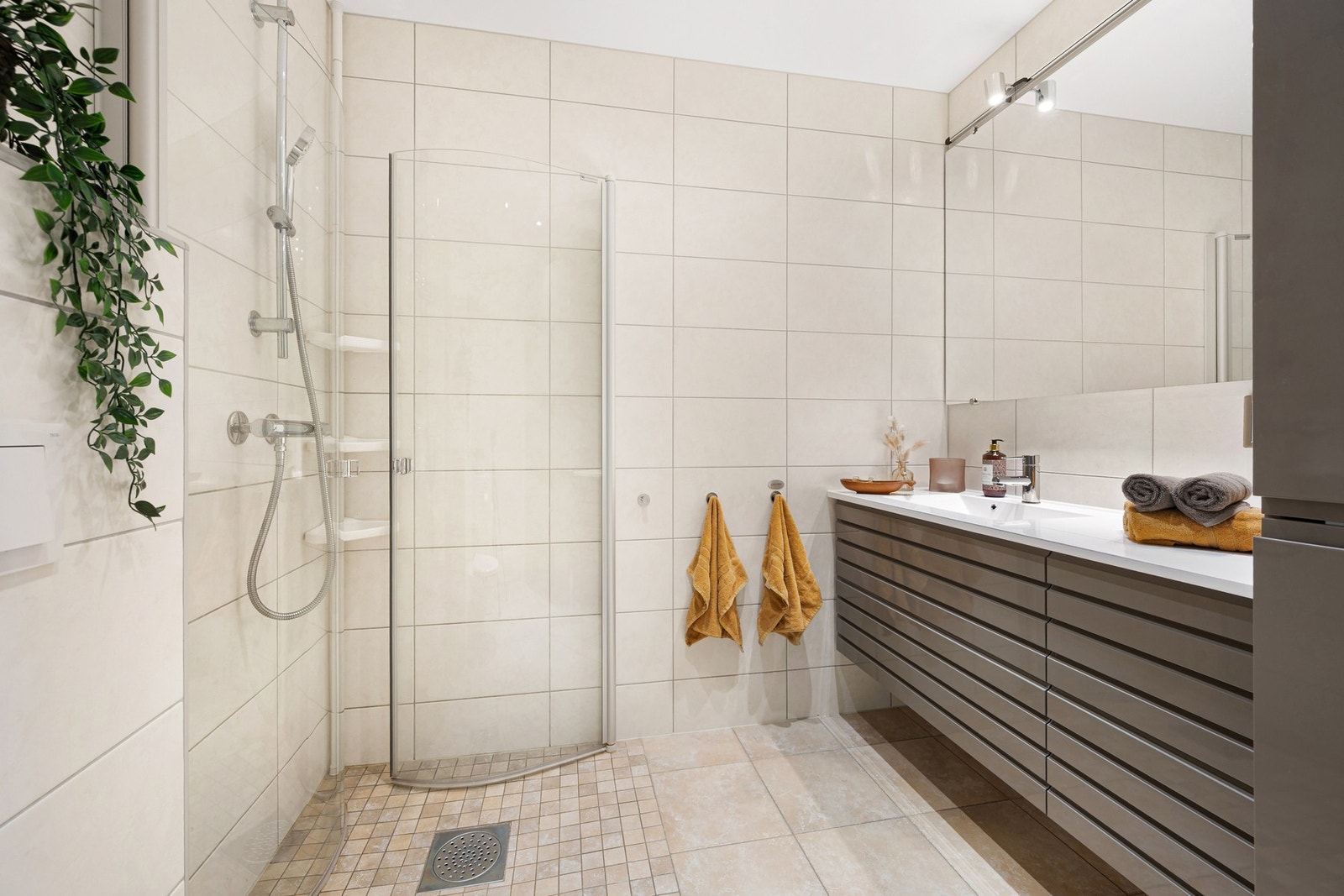 Lekkert og flislagt baderom på 5,3 m² med innredning fra JKE og Kuma. Galleribilde