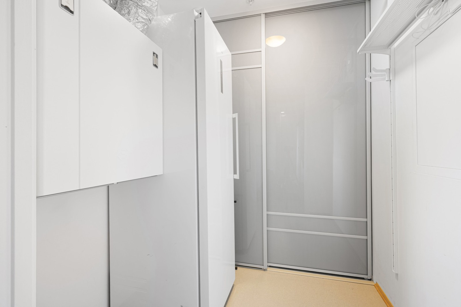 Innvendig bod/teknisk rom på 3,8 m² med plass til ekstra kjøleskap/fryser. Her er det også skyvedørsgarderobe som medfølger handelen. Galleribilde
