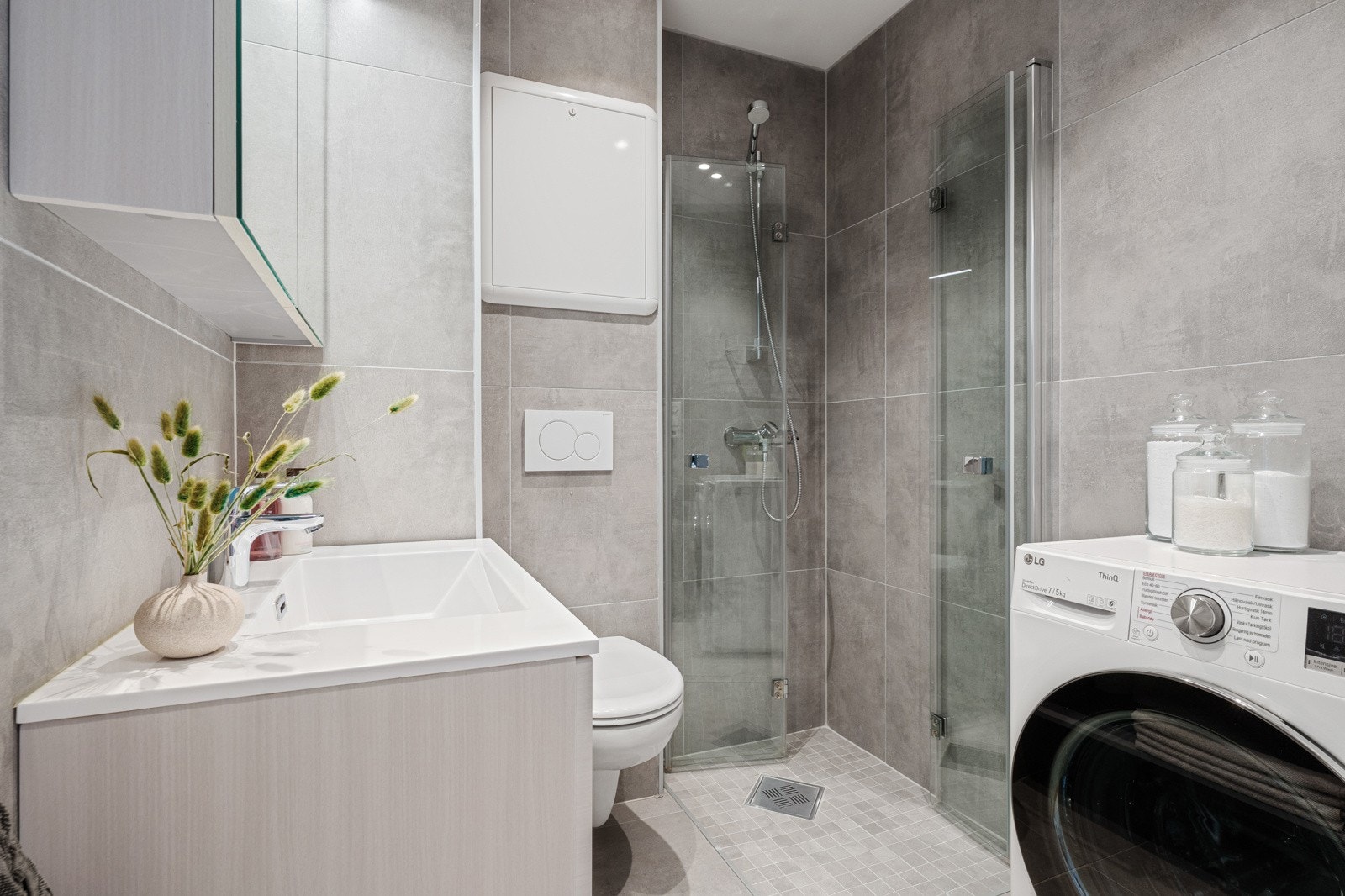 Badet er utstyrt m baderomsinnredning m servant og belyst speil, veggtoalett og foldedører i dusj. Galleribilde