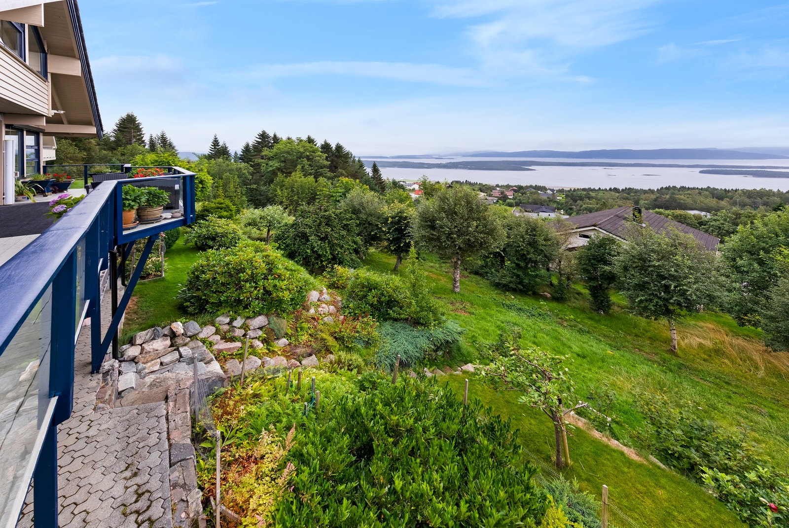 Tomten er opparbeidet med plen, prydbusker og trær Galleribilde