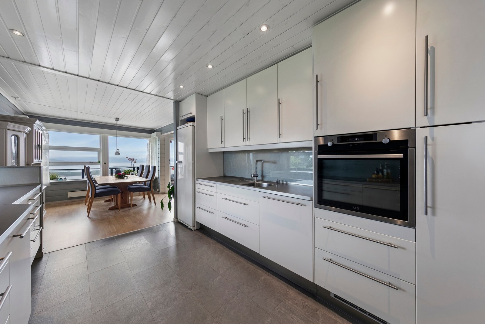 Kjøkkenet har laminatgulv med gulvvarme. Kjøkkeninnredningen har glatte fronter og benkeplate i laminat Galleribilde