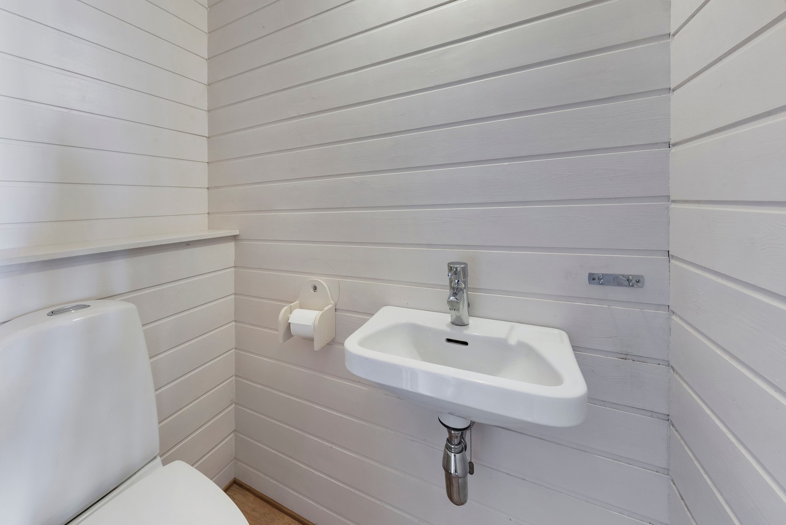 Toalettrom i 1. etasje med vegghengt toalett og servant Galleribilde