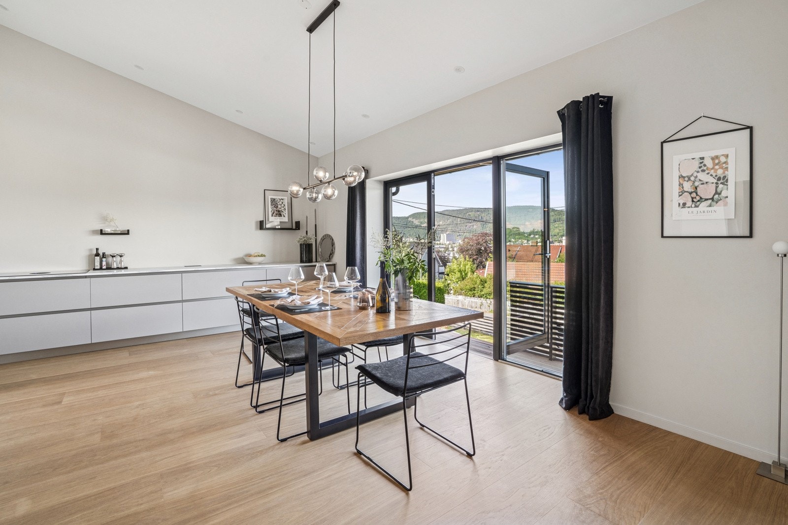 Stilren kjøkken- og spiseavdeling med flott peis og direkte utgang til terrasse. Galleribilde