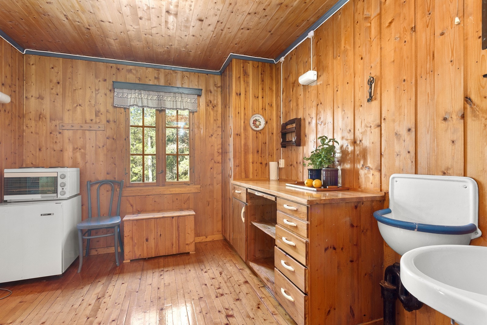 Kjøkkenet er utstyrt med eldre kjøleskap og hybelkomfyr. Galleribilde