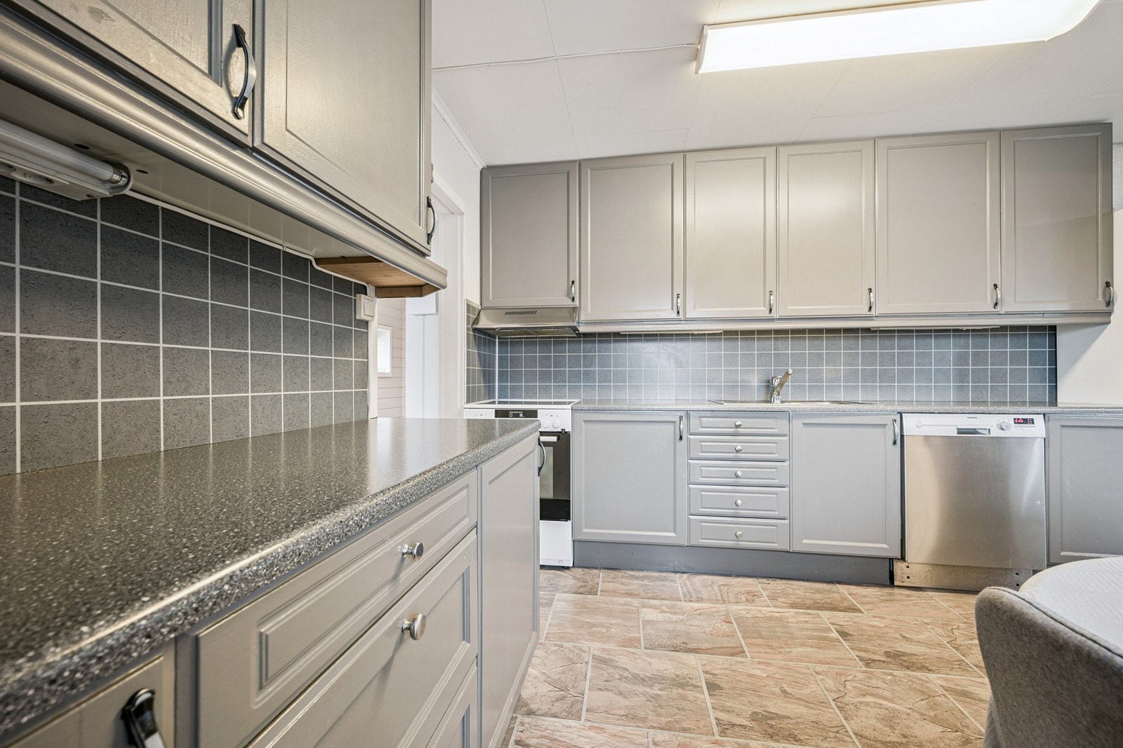 Kjøkkenet har godt med skap- og benkeplass Galleribilde