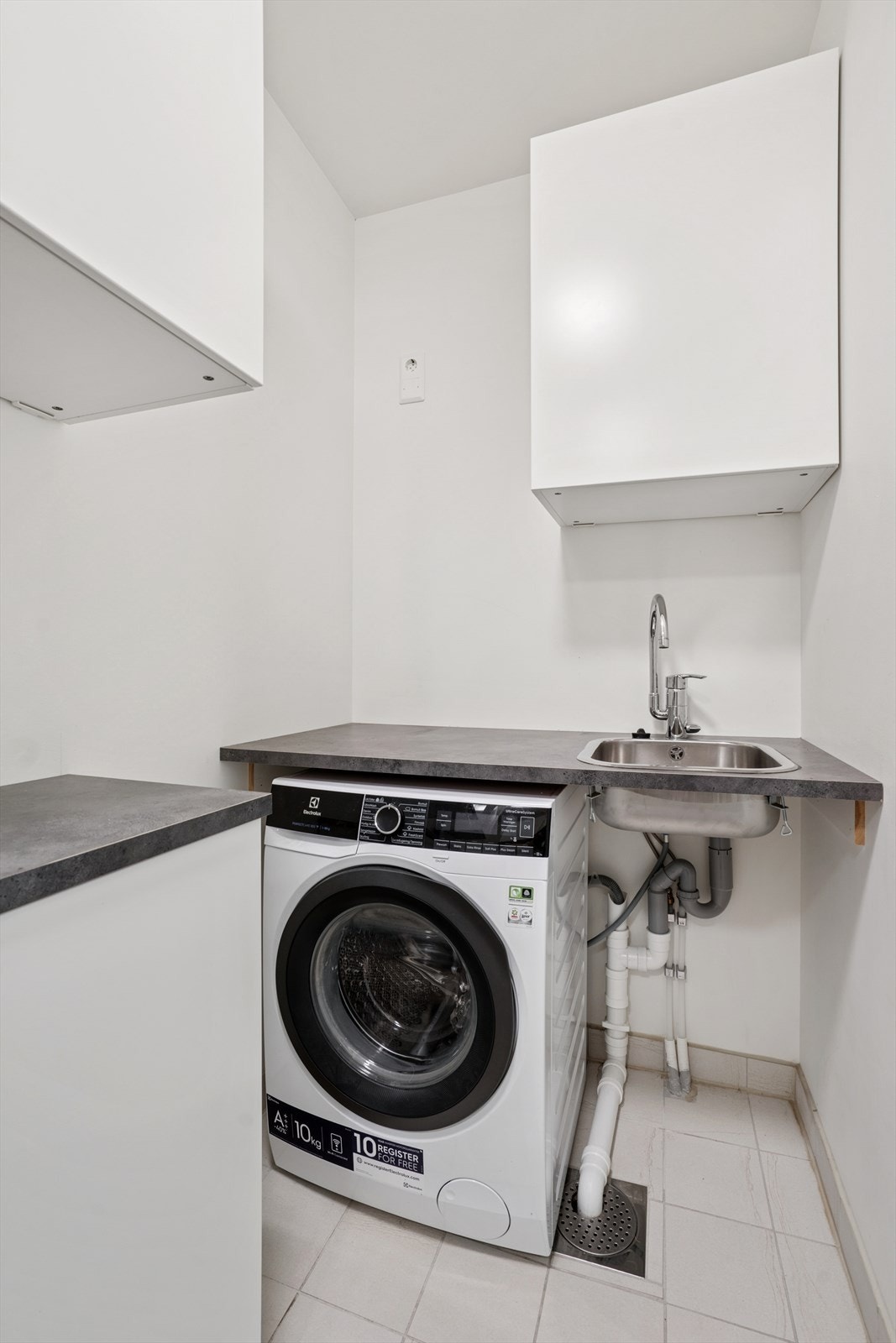 Vaskerommet er innredet med laminat benkeplate med nedfelt vaskekum, skyvedørsgarderobe og overskap, og har opplegg for vaskemaskin. Galleribilde