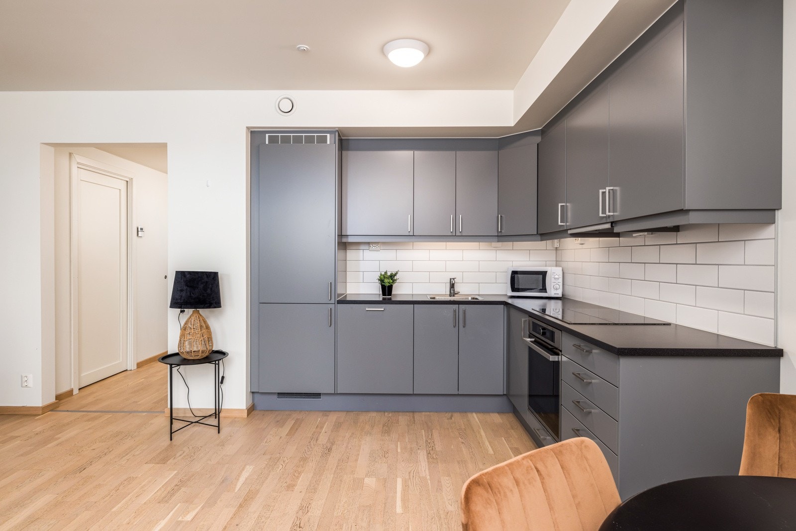 Kjøkkeninnredning i vinkel som ligger i åpen løsning mot stuen. Galleribilde