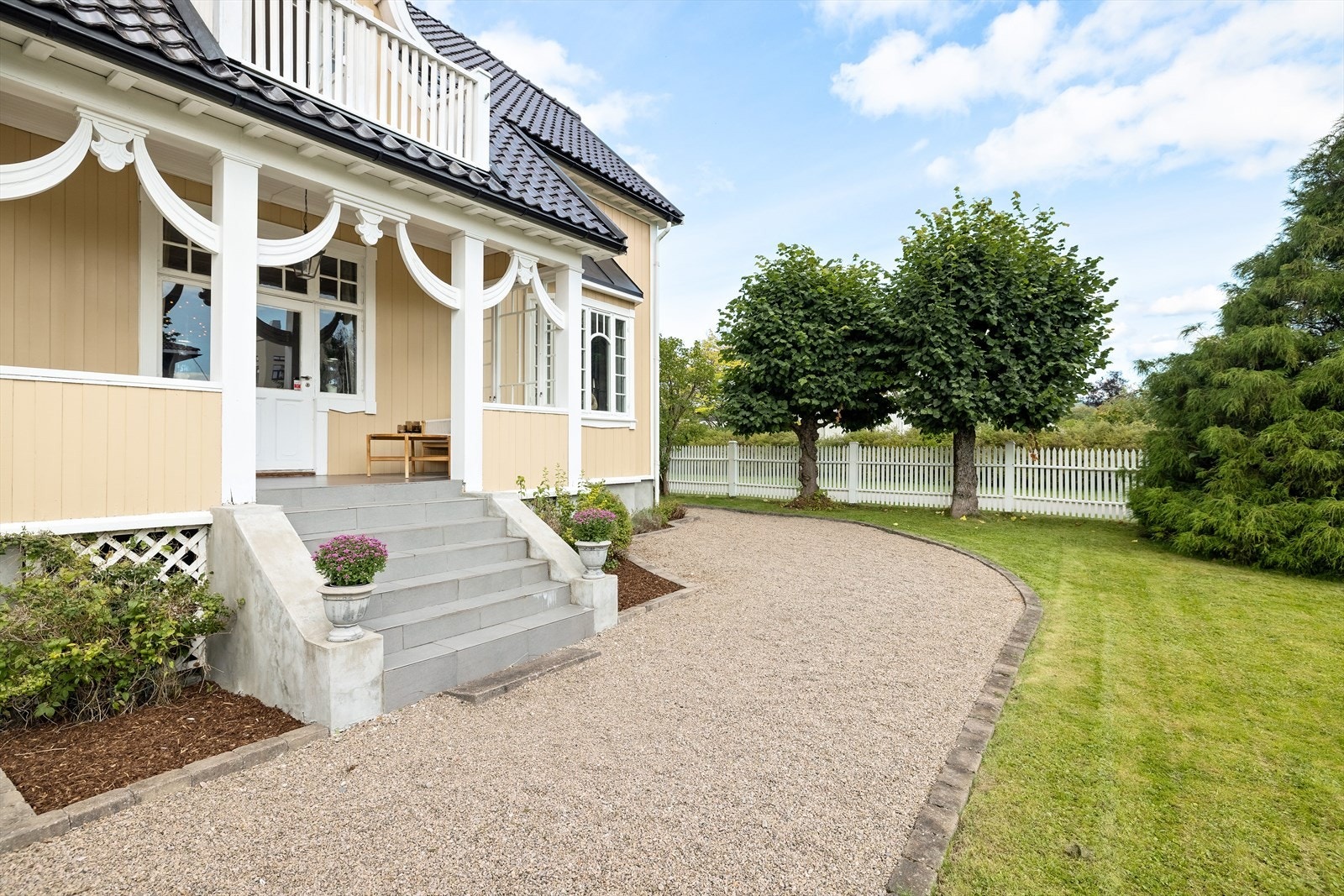 Utenfor stuen er det en lun, overbygget veranda med nedgang til nydelig hageområde Galleribilde