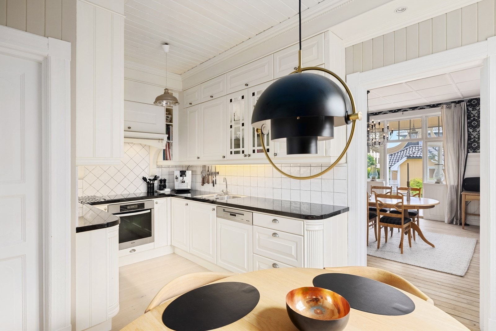 Innredningen har profilerte fronter med innslag av glass og lekker benkeplate i høy kvalitet, type Larvikitt Galleribilde