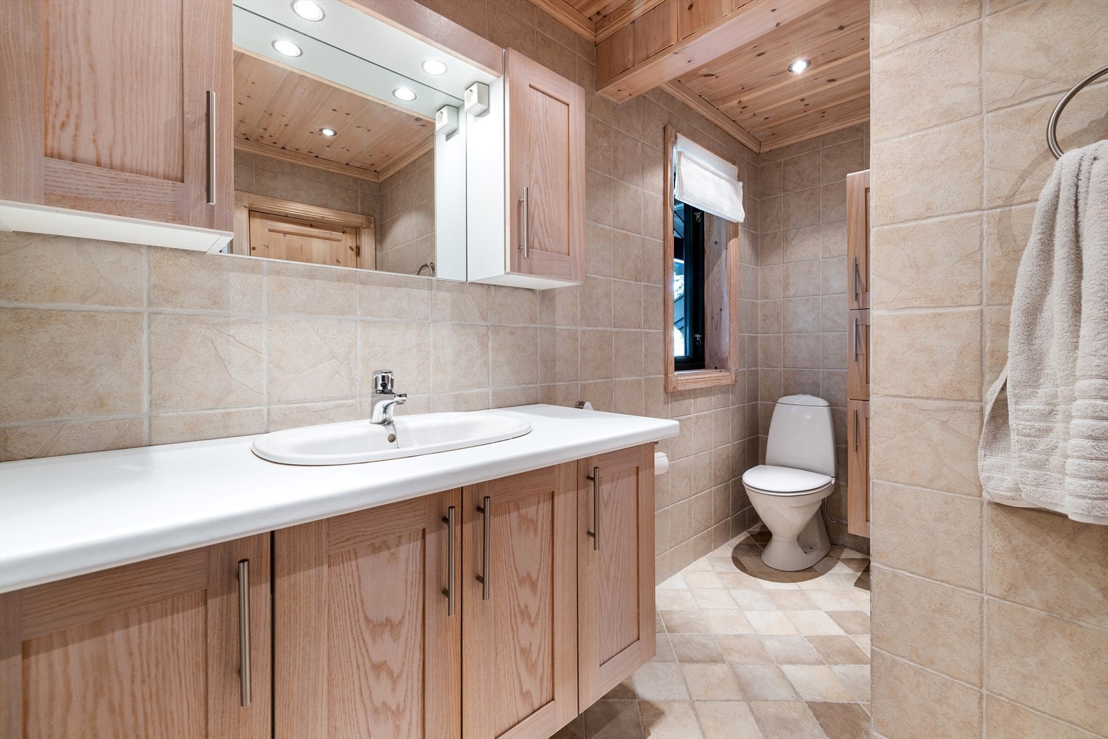 Badet er utstyrt med innredning med nedfelt servant, overskap med integrert belysning, toalett, høyskap, dusjnisje og opplegg for vaskemaskin. Galleribilde