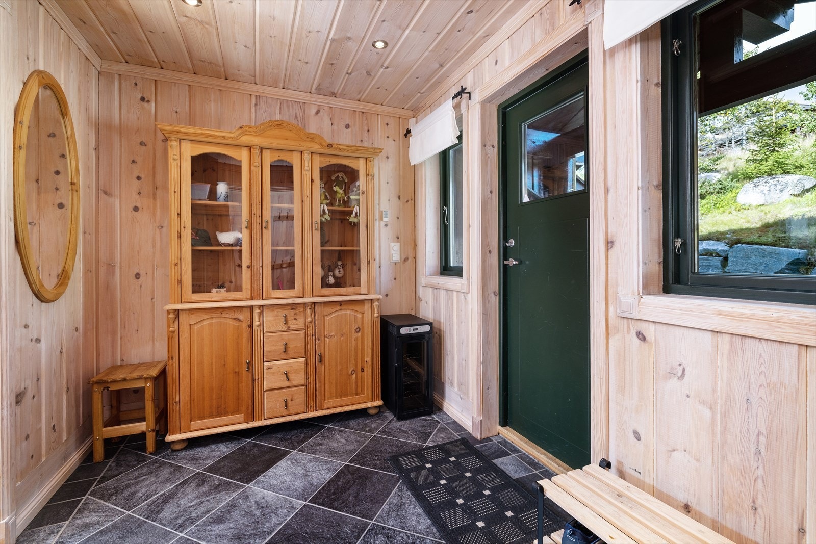 Man ønskes velkommen inn i en romslig gang med flislagt gulv og god plass til å henge fra seg yttertøy. Galleribilde