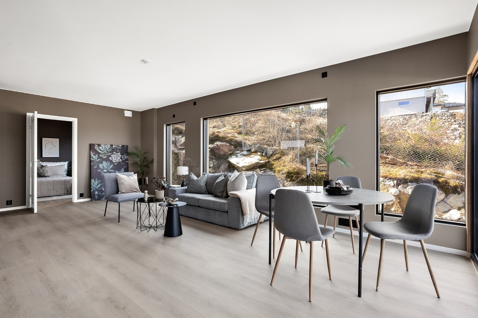 Stue og spiseområde med store vinduer som slipper inn mye lys og leder til et romslig soverom. Galleribilde