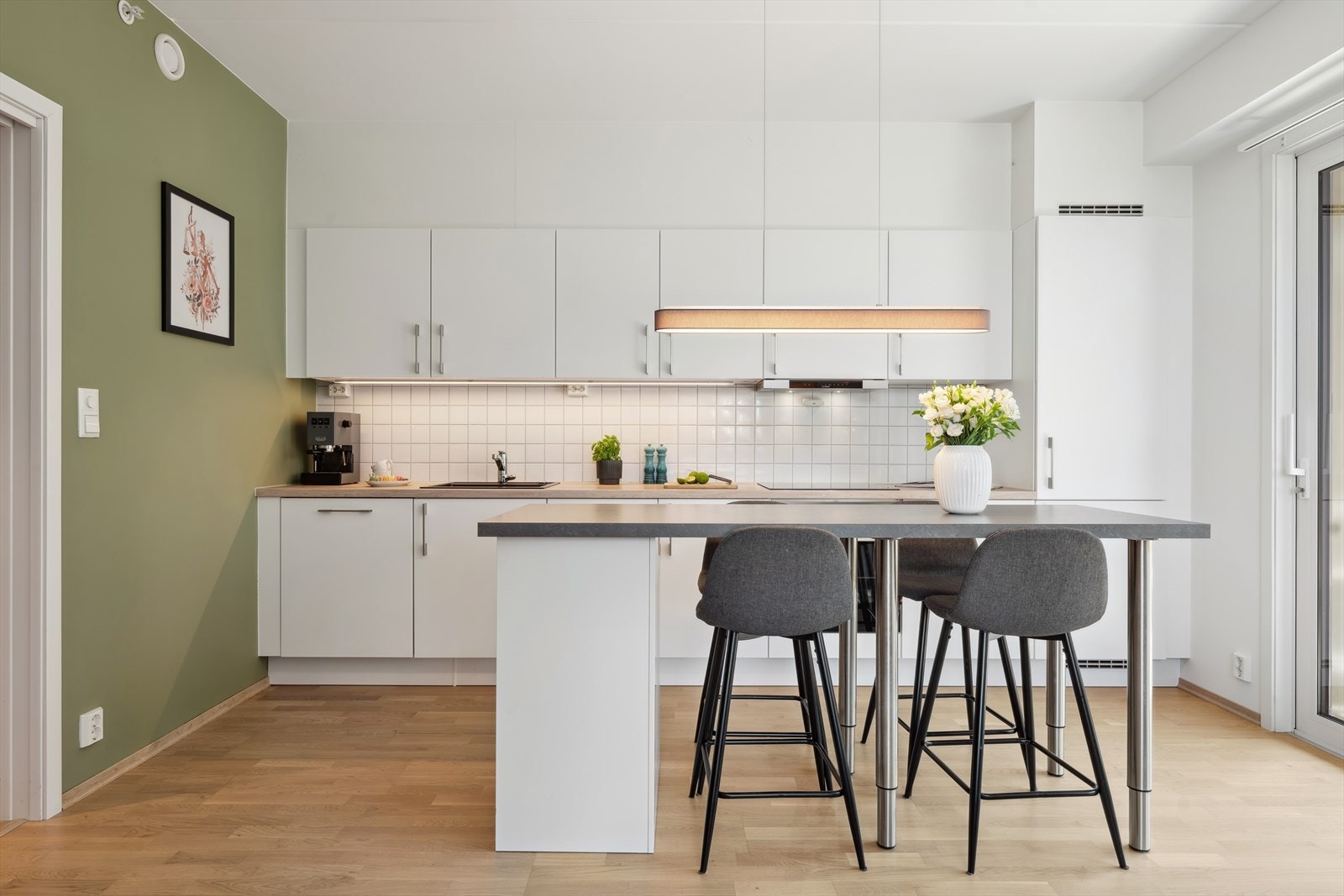 Kjøkkenet har innredning med slette fronter og integrerte hvitevarer Galleribilde