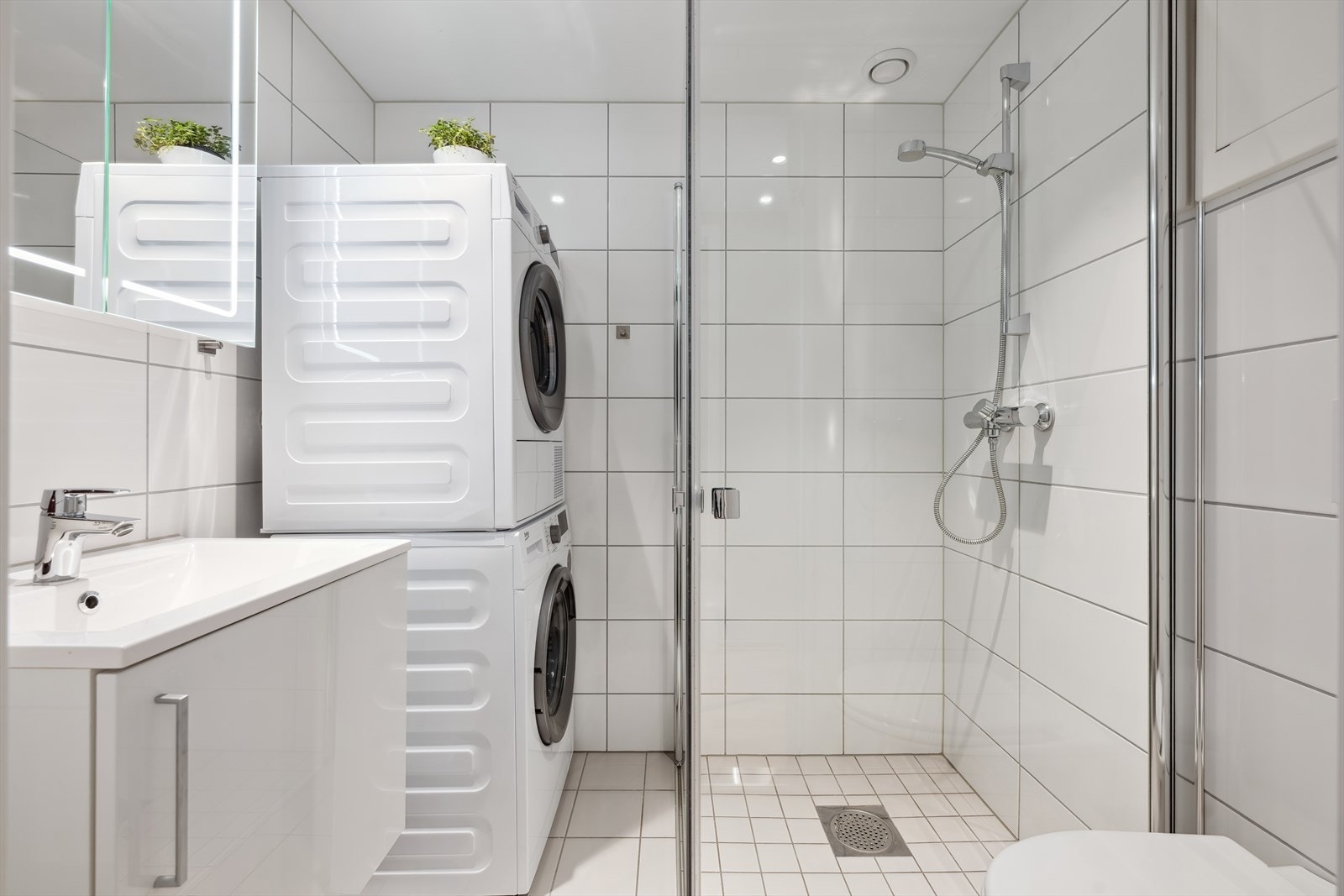 Pent flislagt bad med dusjnisje, vegghengt wc, baderomsinnredning og opplegg for vaskemaskin. Dimbart lys og varmekabler i gulv. Galleribilde