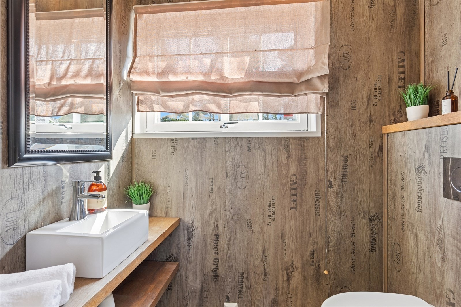 Toalettrommet i boligen er innredet med innebygd wc og servant, og fremstår som både funksjonelt og estetisk tiltalende. Galleribilde