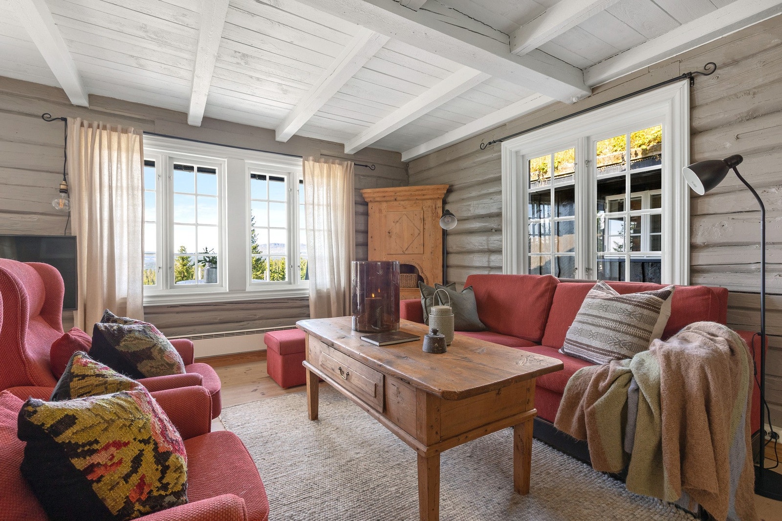 Koselig stue med store vindusflater som slipper naturen inn og gir en luftig atmosfære. Galleribilde