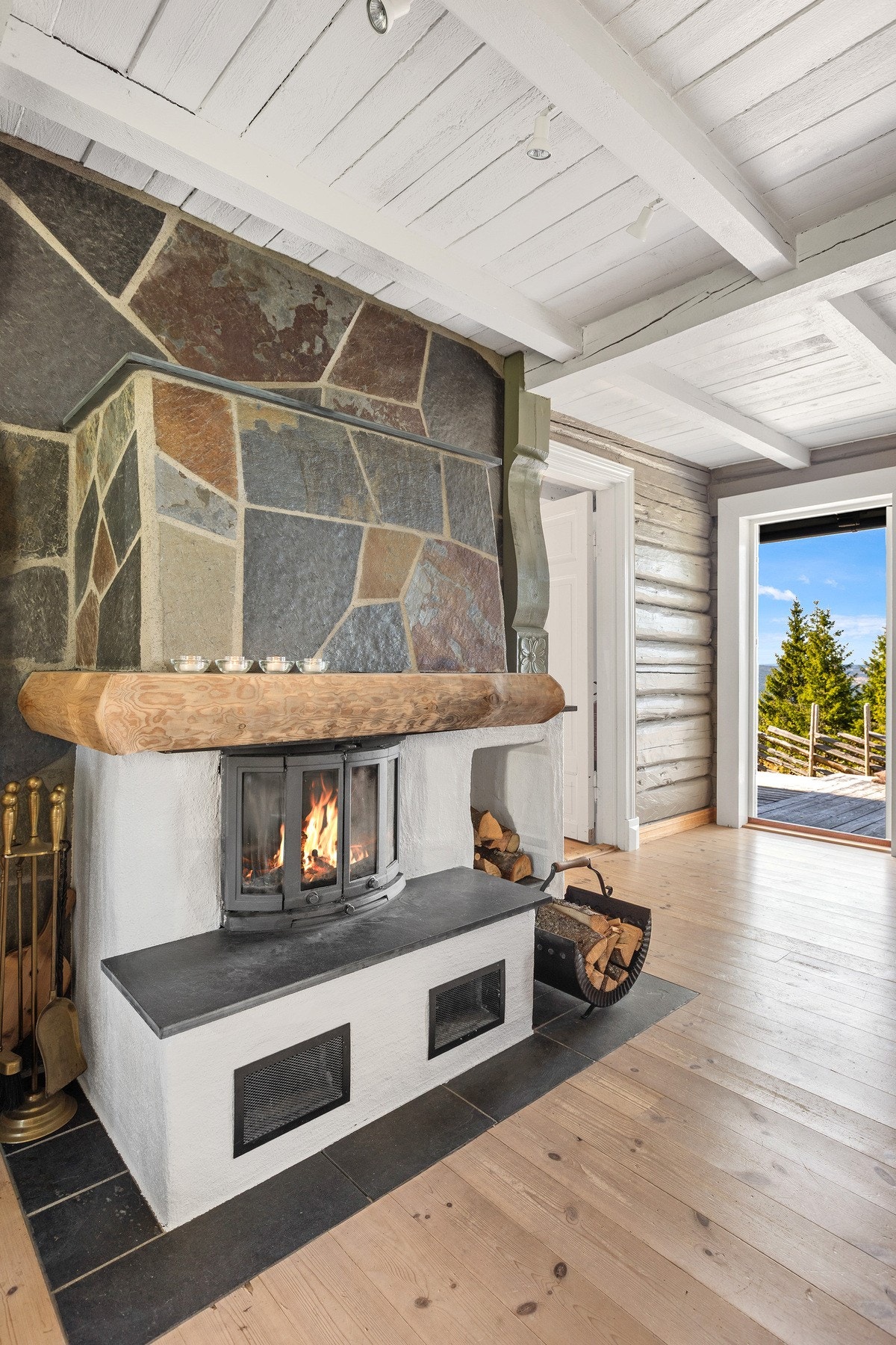 Peisen i naturstein blir et naturlig midtpunkt som sprer varme og skaper ekte hygge på kalde vinterdager. Galleribilde