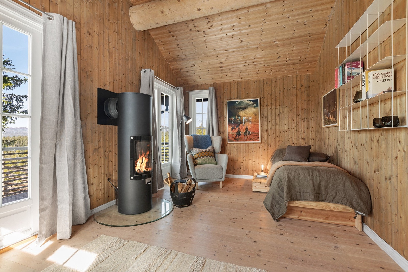 Den påbygde delen av hytta rommer en koselig stue med moderne peisovn og direkte utgang til terrassen. Galleribilde