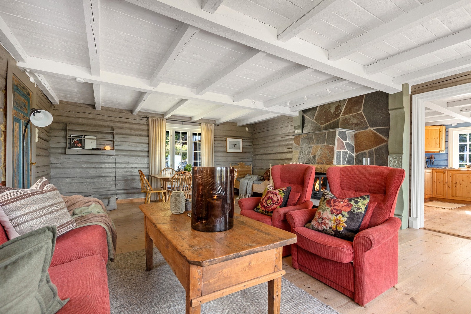 De lyse tregulvene og de hvitmalte takbjelkene gir rommet et åpent og luftig preg, mens de tømrede veggene tilfører den klassiske hyttestemningen man forbinder med fjellet. Galleribilde