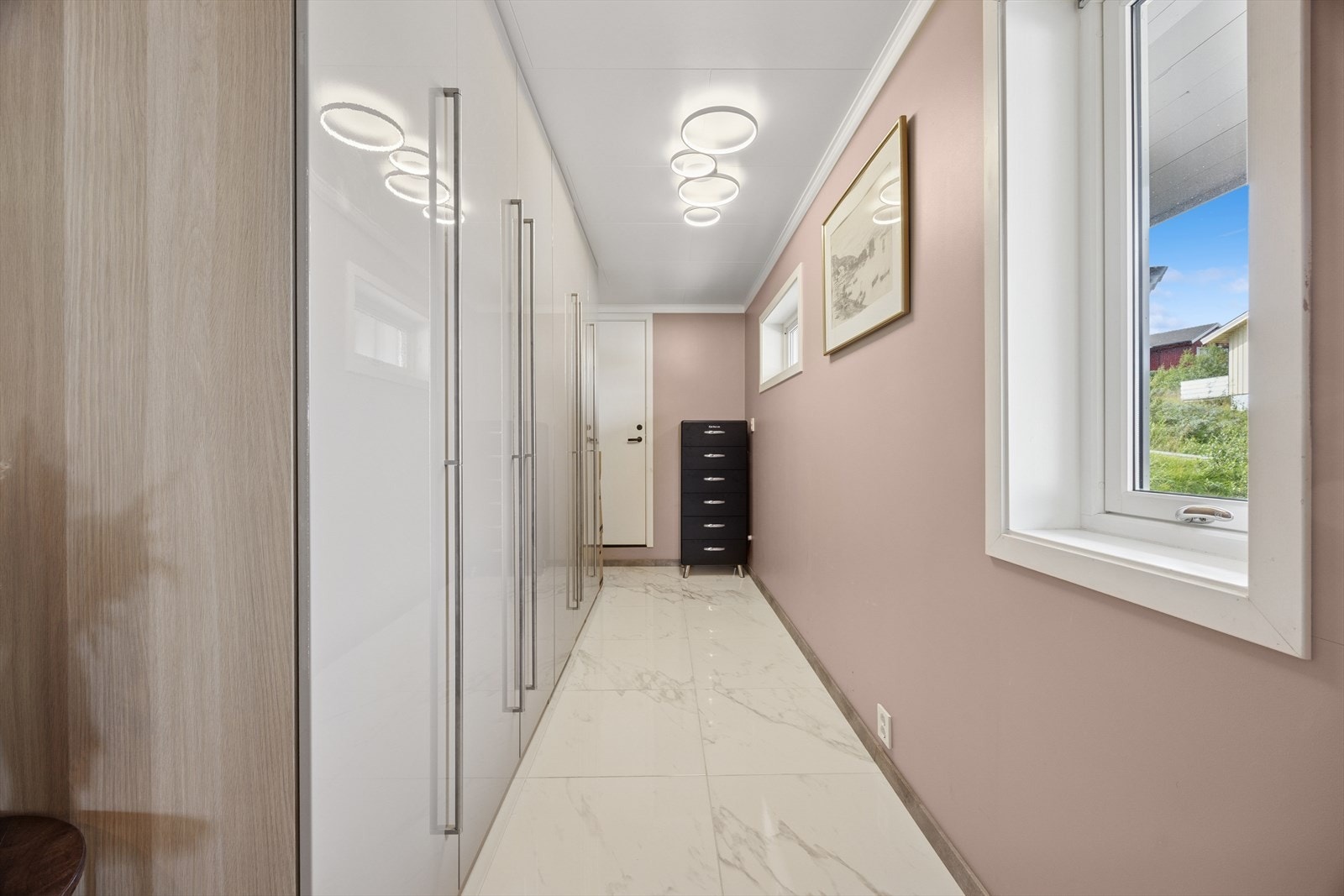 Her er det enkelt å holde orden med garderobeløsninger og skooppbevaring - perfekt for en aktiv hverdag med mange behov. Entreen gir et flott førsteinntrykk og fungerer som et praktisk knutepunkt i boligen. Tilgang til garasje i enden av gangen. Galleribilde