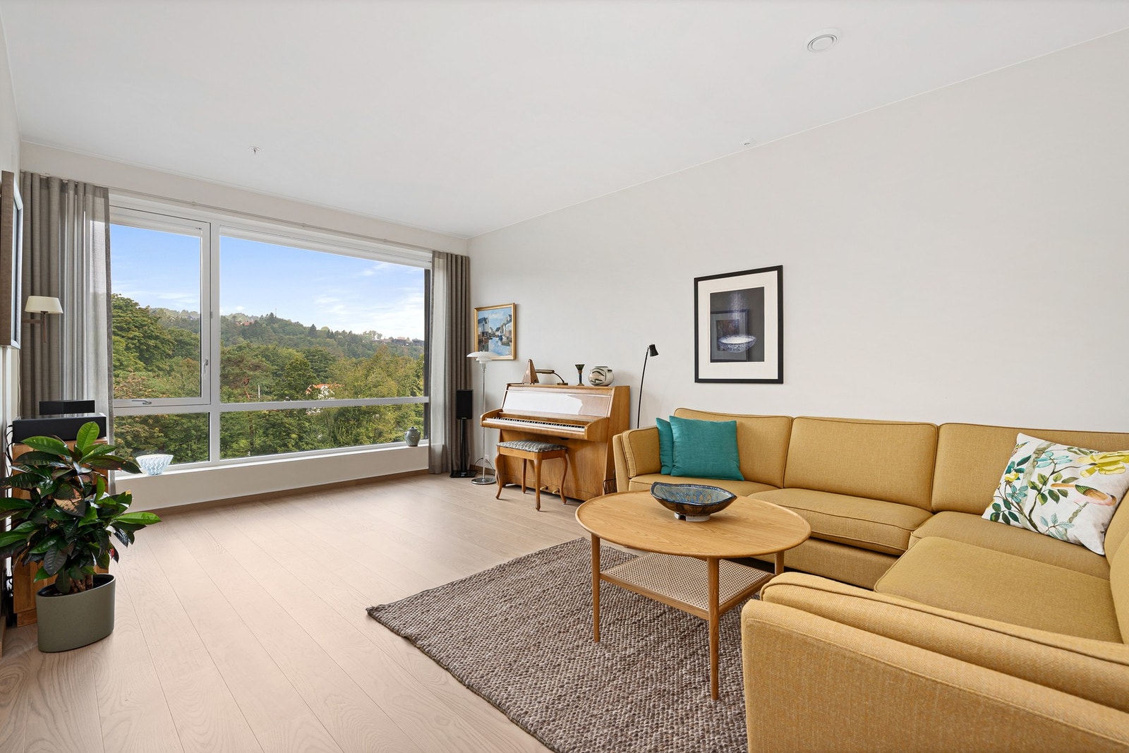 Flott lys inn i stuen fra det store vinduet mot grøntarealene utenfor Galleribilde