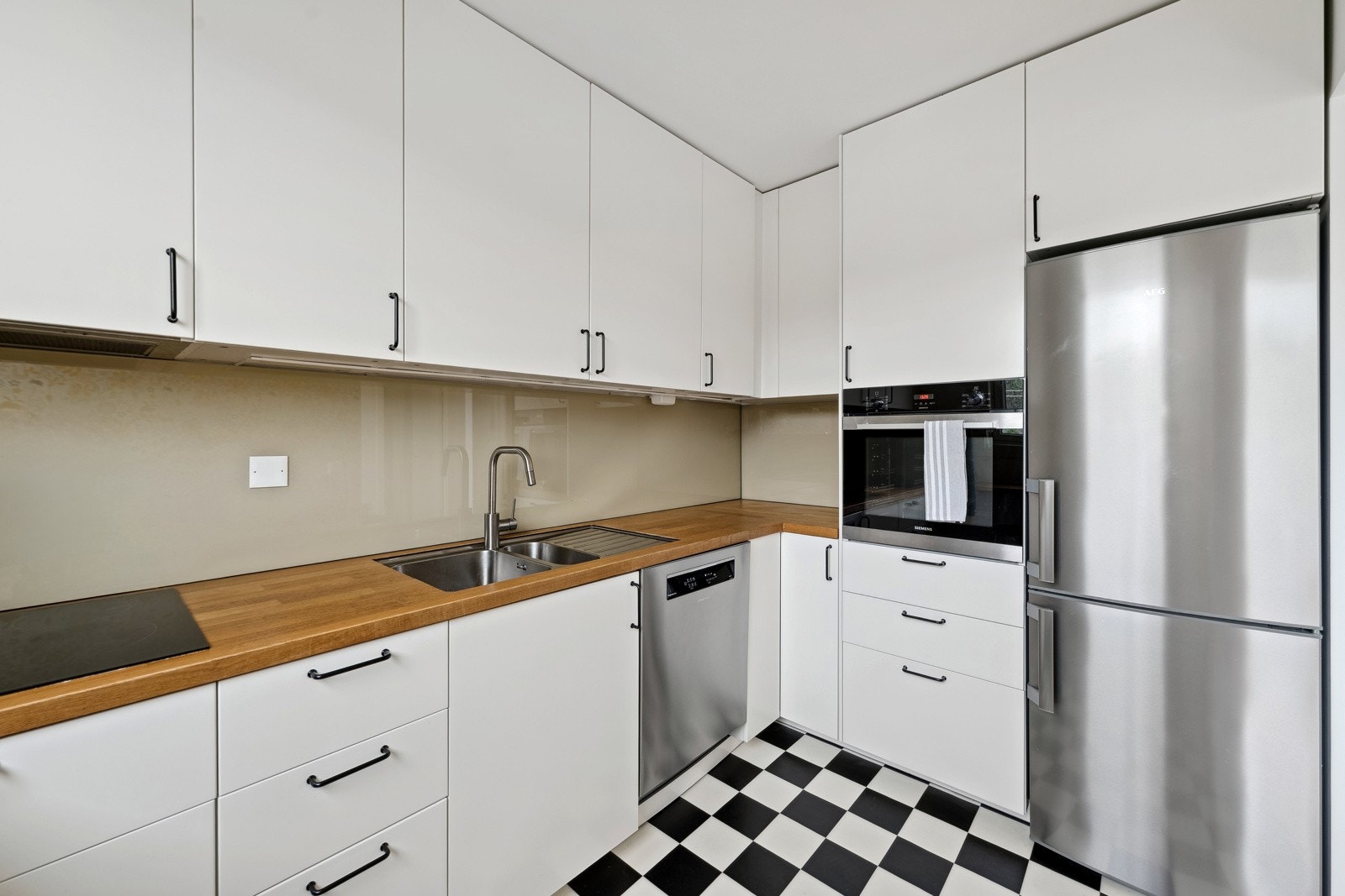 Kjøkken med takhøy innredning og heltre benkeplate i eik. Galleribilde