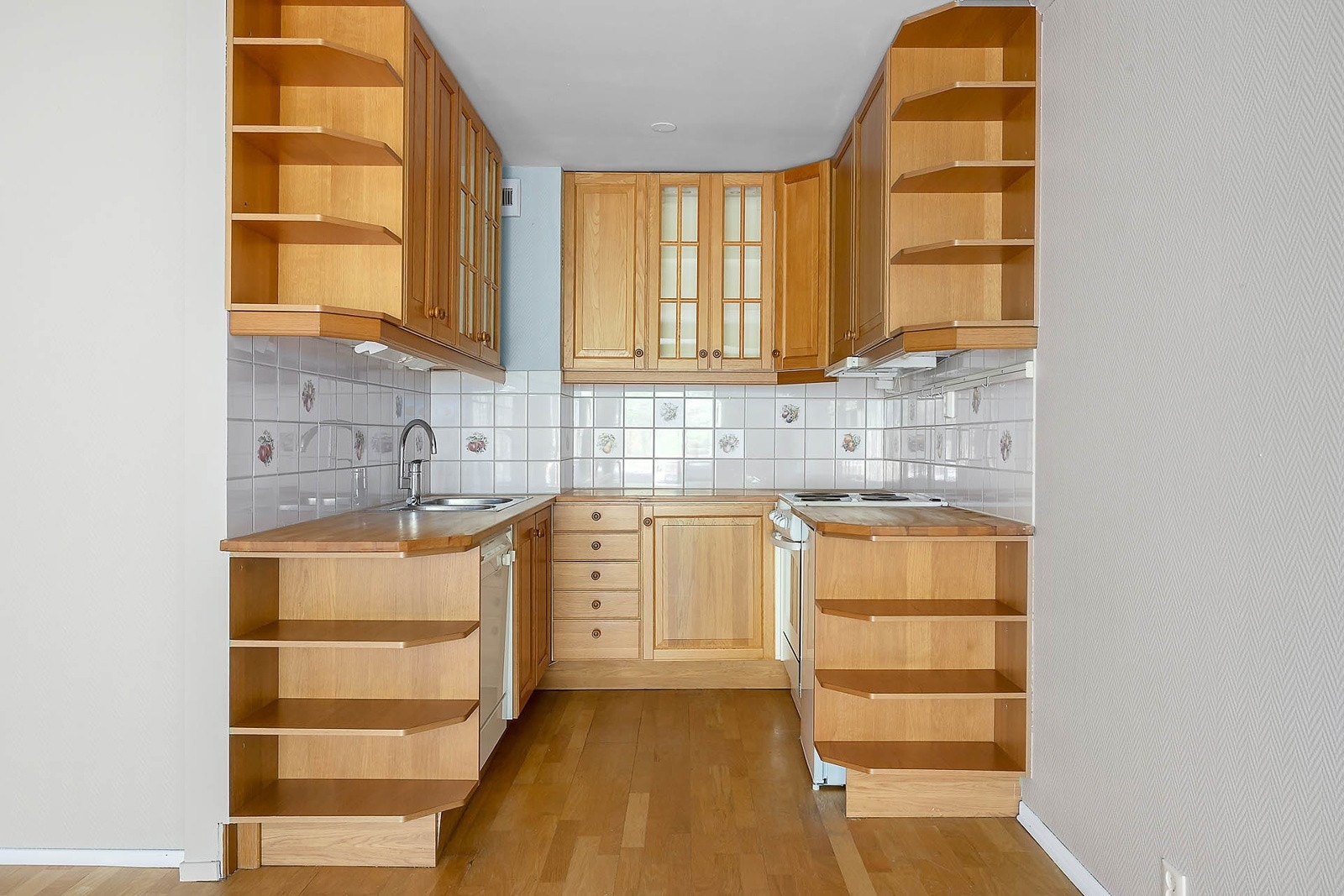 Kjøkkeninnredning i Furu. Kjøkkenet har hvitevarer som komfyr og oppvaskmaskin. Galleribilde